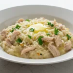 tigela de risoto de frango cremoso em bancada de quartzo